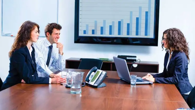 financial business meeting with 3 people in a conference room