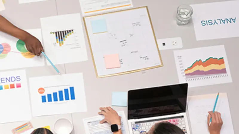 a group of people looking at several financial reports